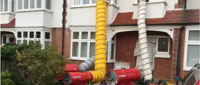  front side of the apartment building with industrial fans connected to flex ducts