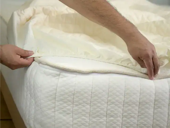 mattress protector  sheet being put on